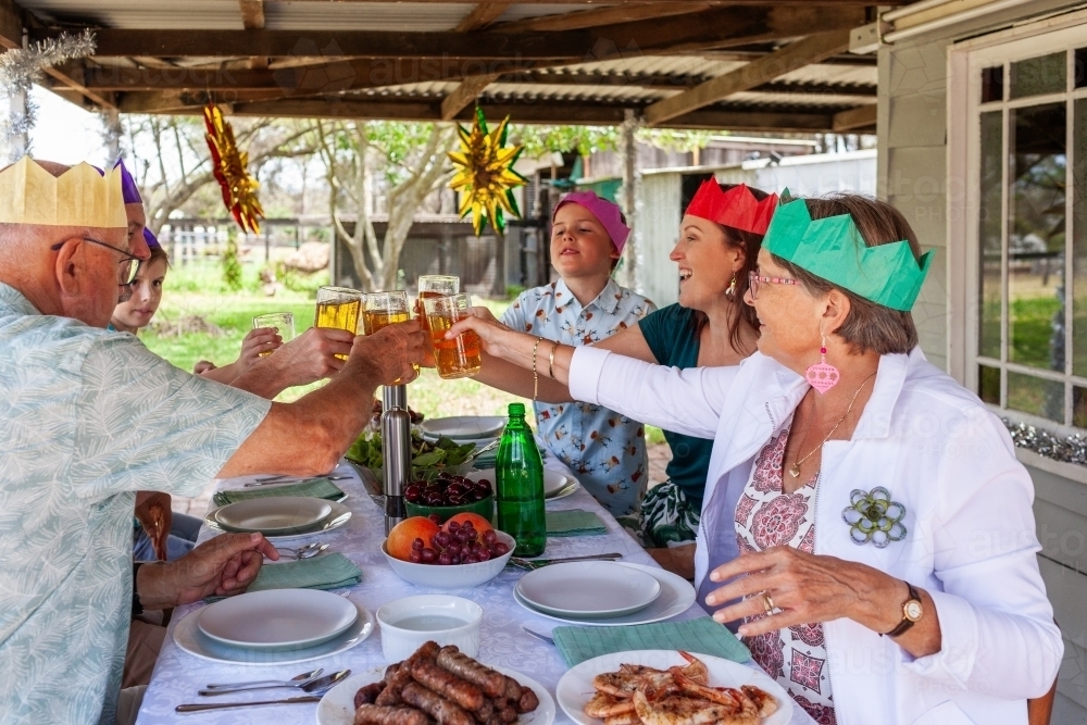 Australian family together at Christmas lunch toasting with sparkling apple juice - Australian Stock Image