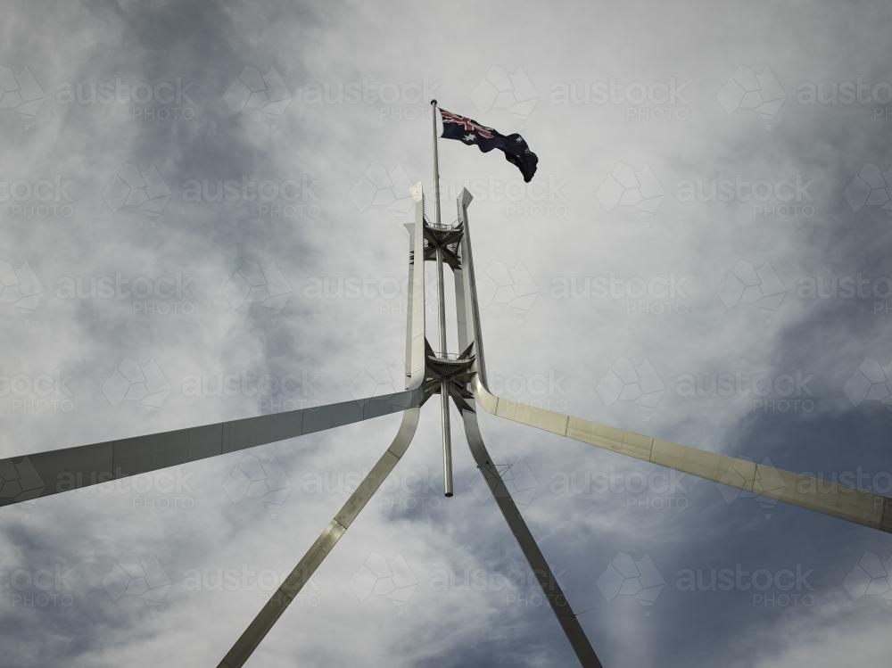Australian Flag flying at Parliament house seen from below - Australian Stock Image
