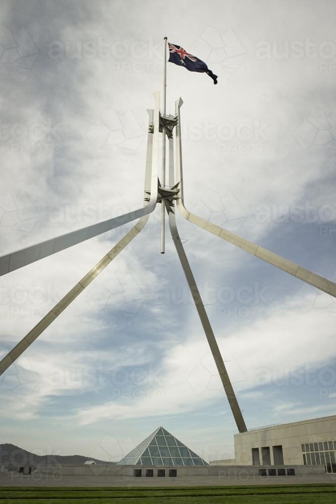 Australian Flag flying at Parliament House seen from below - Australian Stock Image
