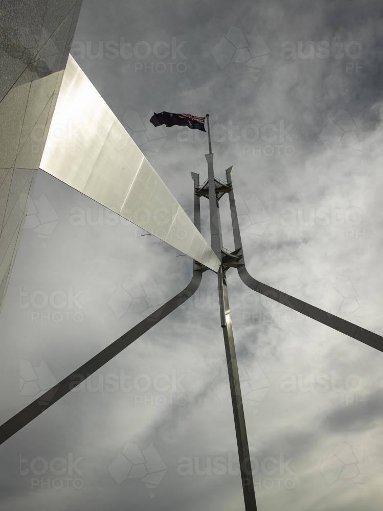 Australian Flag flying at Parliament house seen from below - Australian Stock Image