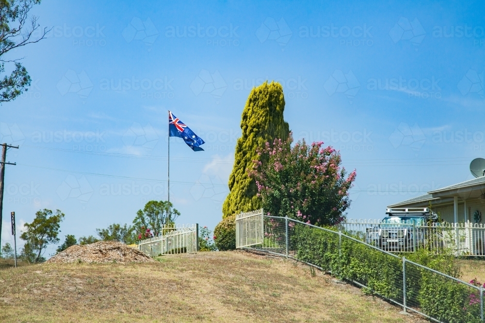 Australian flag flying on pole outside home - Australian Stock Image