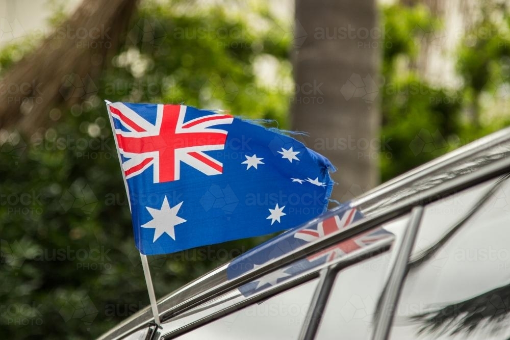 Australian flag flying out the window of a car - Australian Stock Image