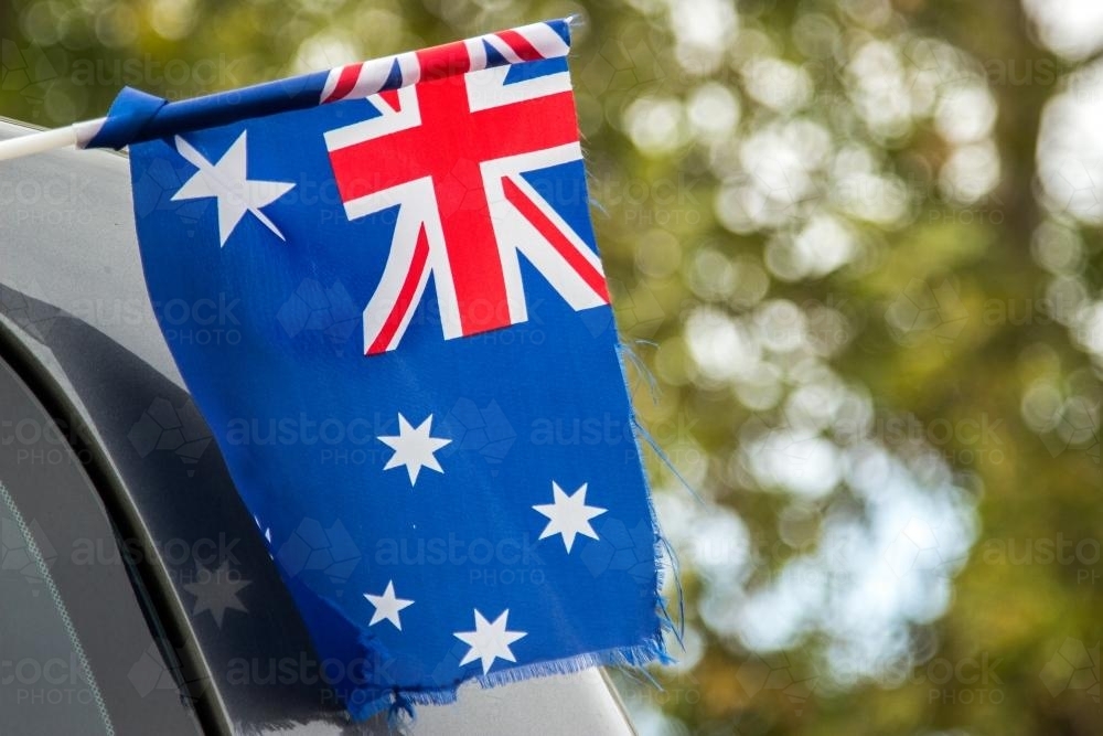 Australian flag flying out the window of a car - Australian Stock Image