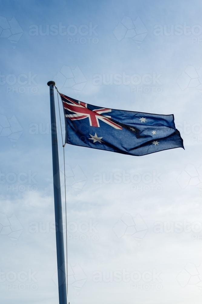 Australian flag on a pole against a blue sky - Australian Stock Image