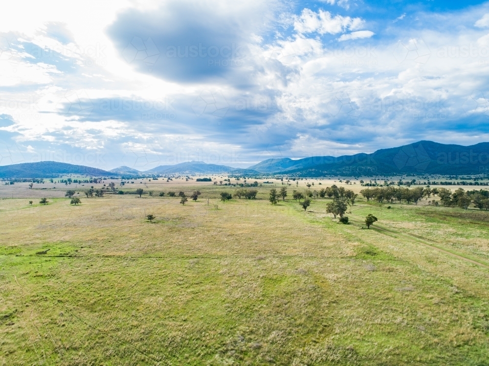 Image of Australian landscape of green farm paddock expanse with clouds
