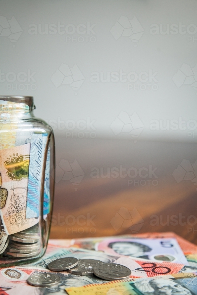 Australian notes and coins in a jar with copy space - Australian Stock Image