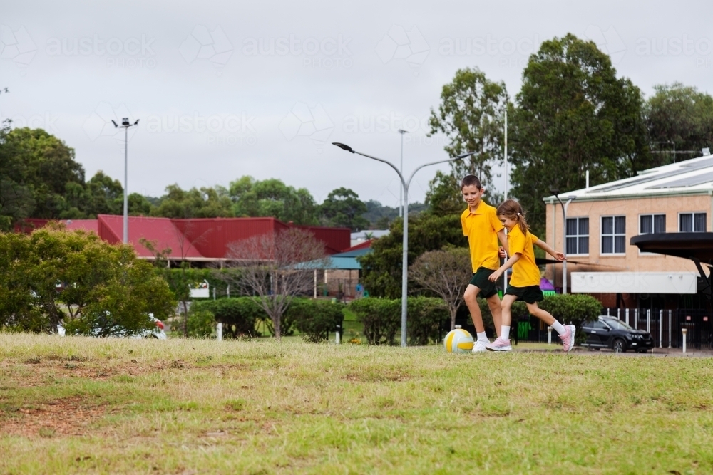 Australian primary school students running after a ball - Australian Stock Image