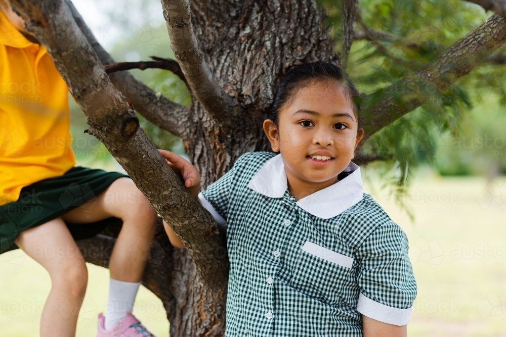 Australian school girl with filipino heritage outside under a tree - Australian Stock Image