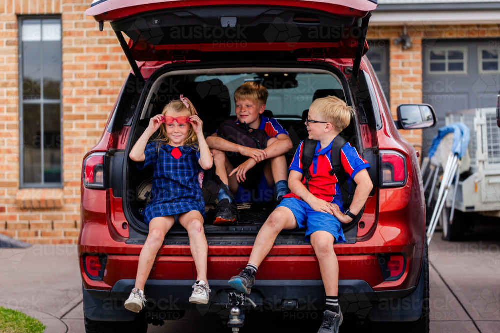 Australian school kids in family car boot ready for school drop off waiting outside home - Australian Stock Image