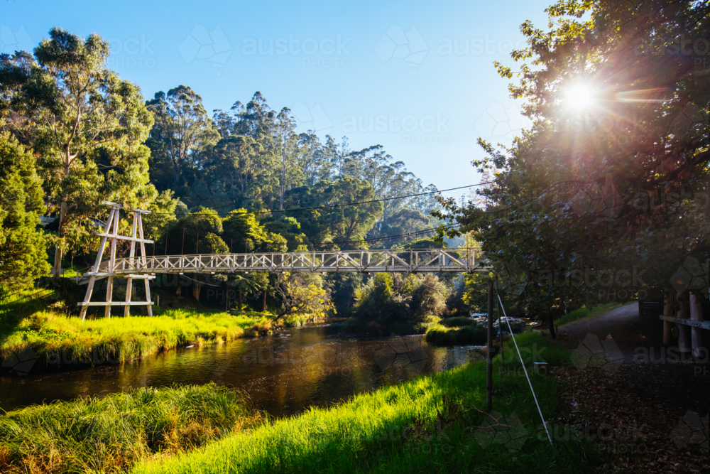 Autumn morning light is cast over the Yarra River on the Yarra River Walk trail at Warburton - Australian Stock Image