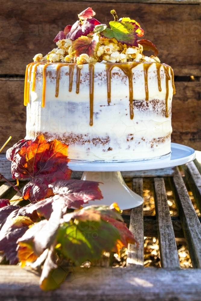 Autumn styled layer cake with caramel drizzle and popcorn - Australian Stock Image