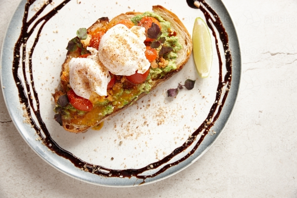 Image of avocado toast with tomatoes and white cheese on top Austockphoto