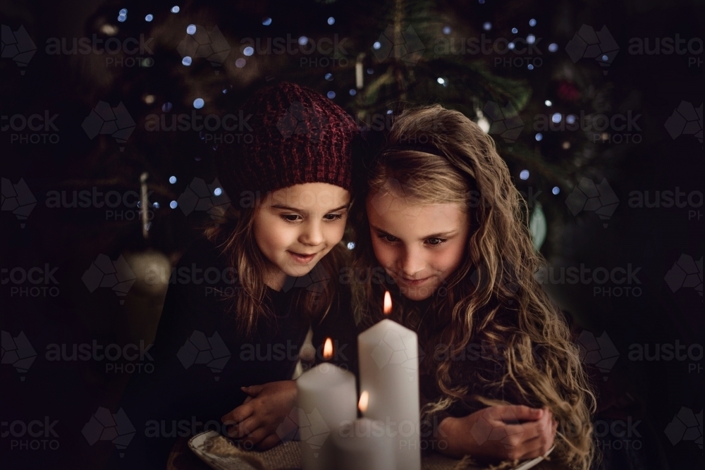 Two young children look at candles at Christmas time - Australian Stock Image
