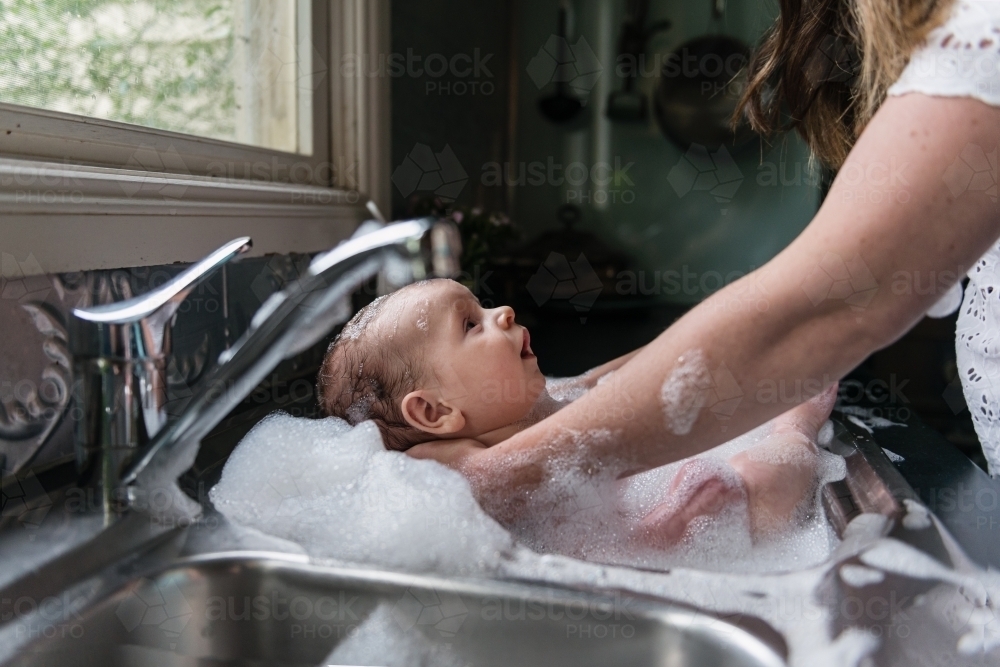 Baby bath in kitchen sink - Australian Stock Image