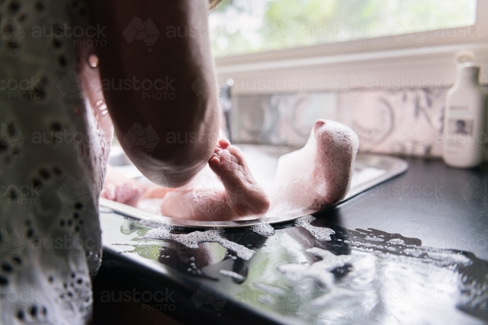 Baby bath in kitchen sink - Australian Stock Image
