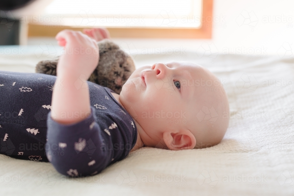Baby boy laying on back side profile - Australian Stock Image