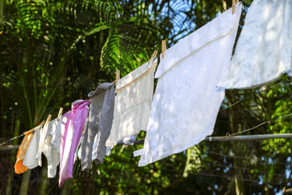 Baby clothes drying on clothes line. - Australian Stock Image