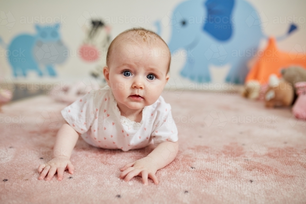 Baby girl having tummy time - Australian Stock Image