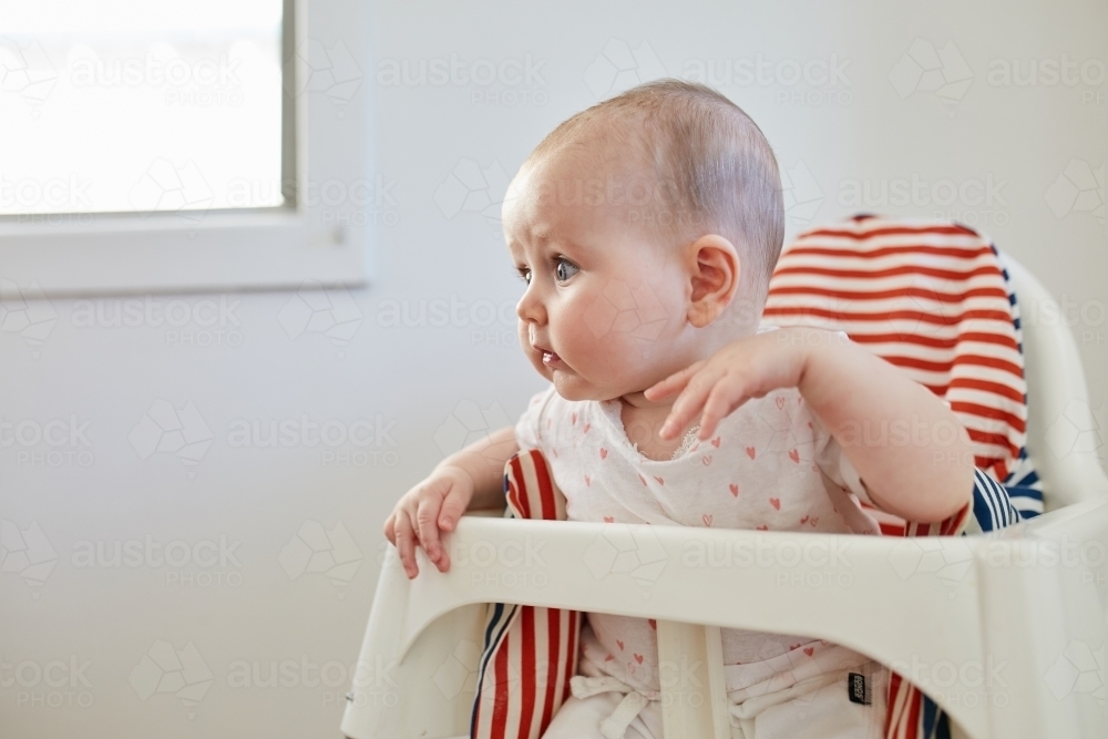 Baby girl in high chair - Australian Stock Image