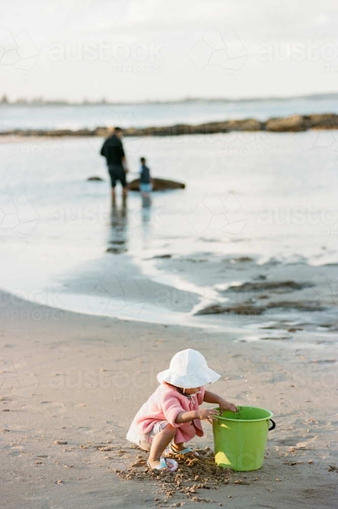 Baby Girl Playing with Sand with her Family - Australian Stock Image