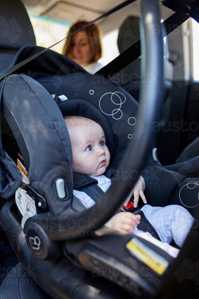 Baby lying in car seat - Australian Stock Image
