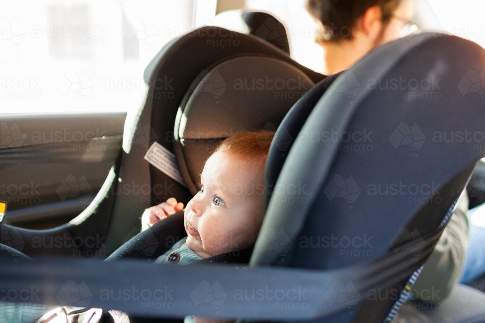 Image of baby strapped into rear facing child car seat with parent in