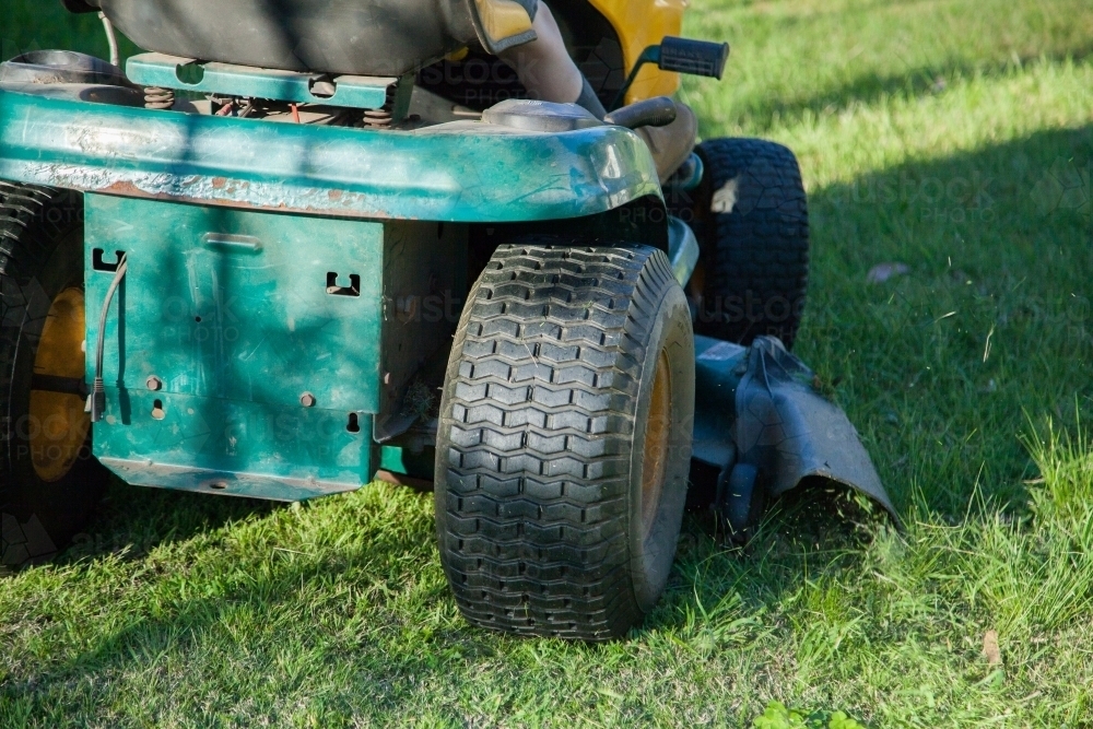 Back of a green ride on lawn mower cutting the grass - Australian Stock Image