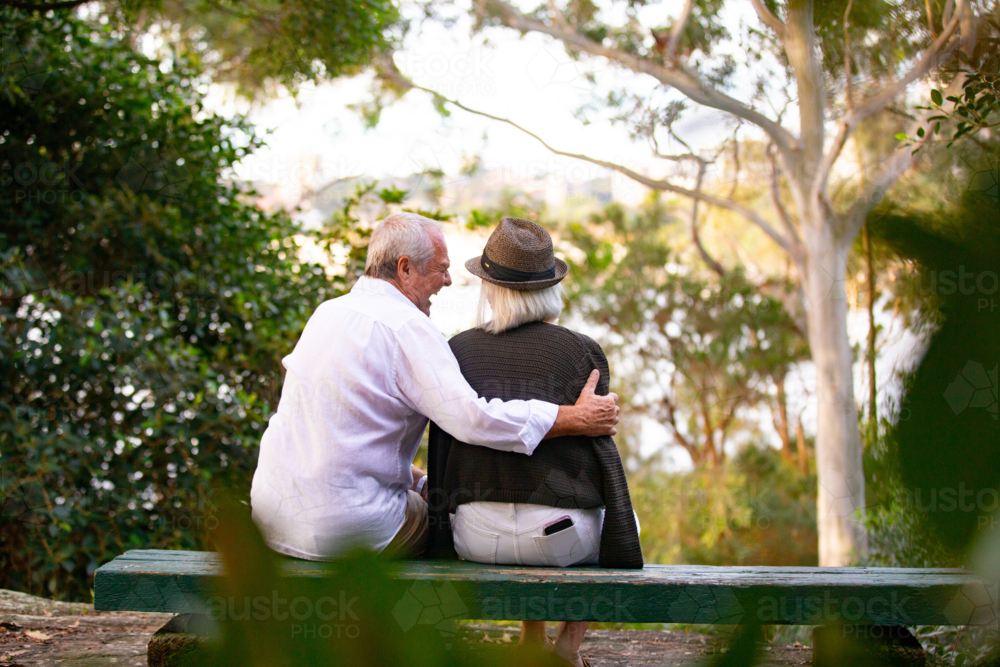 Image of Back view of Senior couple sitting on park bench - Austockphoto