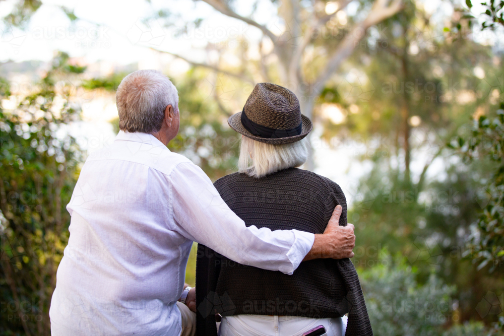 Image of Back view of Senior couple sitting on park bench - Austockphoto