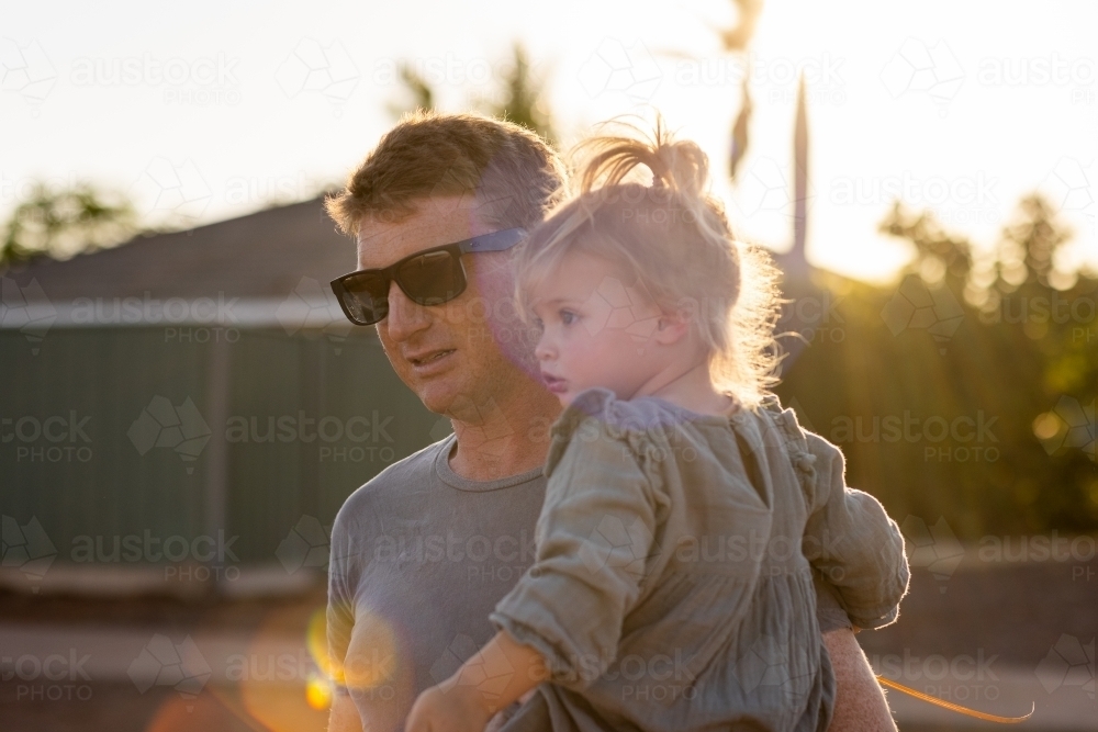 backlit father and child with sunflare - Australian Stock Image