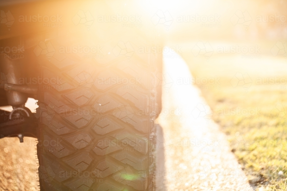 Backlit four wheel drive car tyre on the road - Australian Stock Image