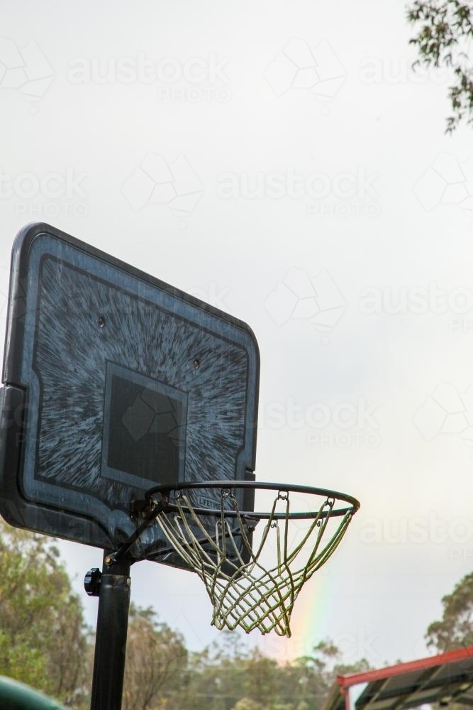 Backyard basketball hoop and a rainbow - Australian Stock Image