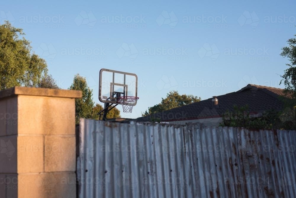 Backyard basketball in the suburbs at sunset - Australian Stock Image