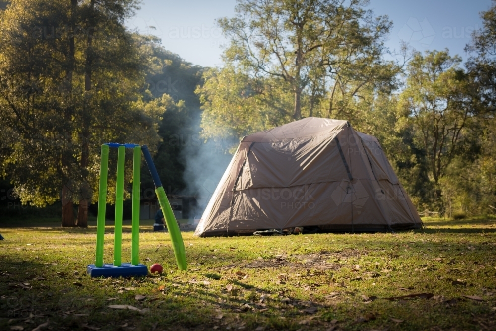 Backyard cricket stumps, bat and ball sit unused on a camping trip - Australian Stock Image