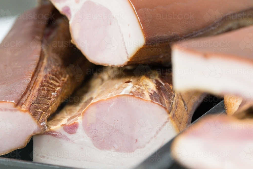 Bacon waiting to be sliced in butchers shop - Australian Stock Image