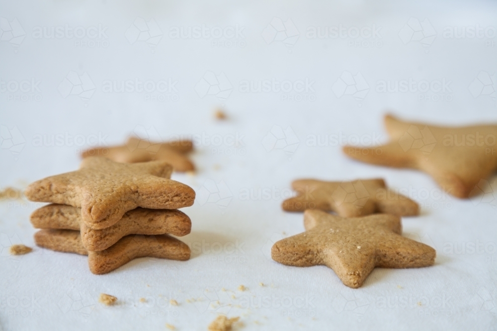 Baked gingerbread christmas star biscuits on white - Australian Stock Image