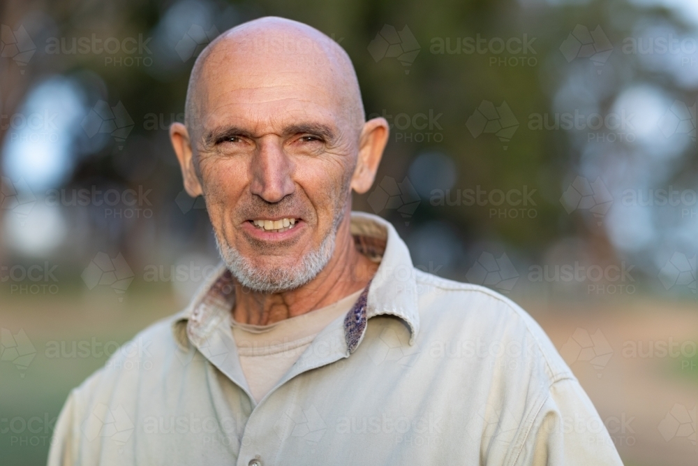 bald man outdoors with blurred bush background - Australian Stock Image