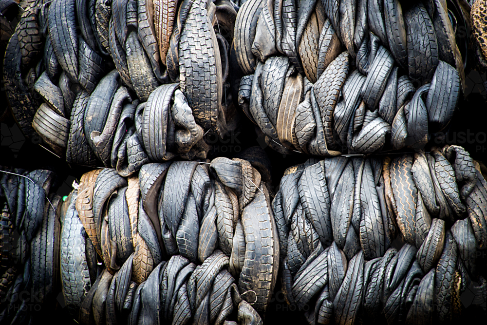Bales of tightly compressed worn-out tyres stacked for recycling. - Australian Stock Image