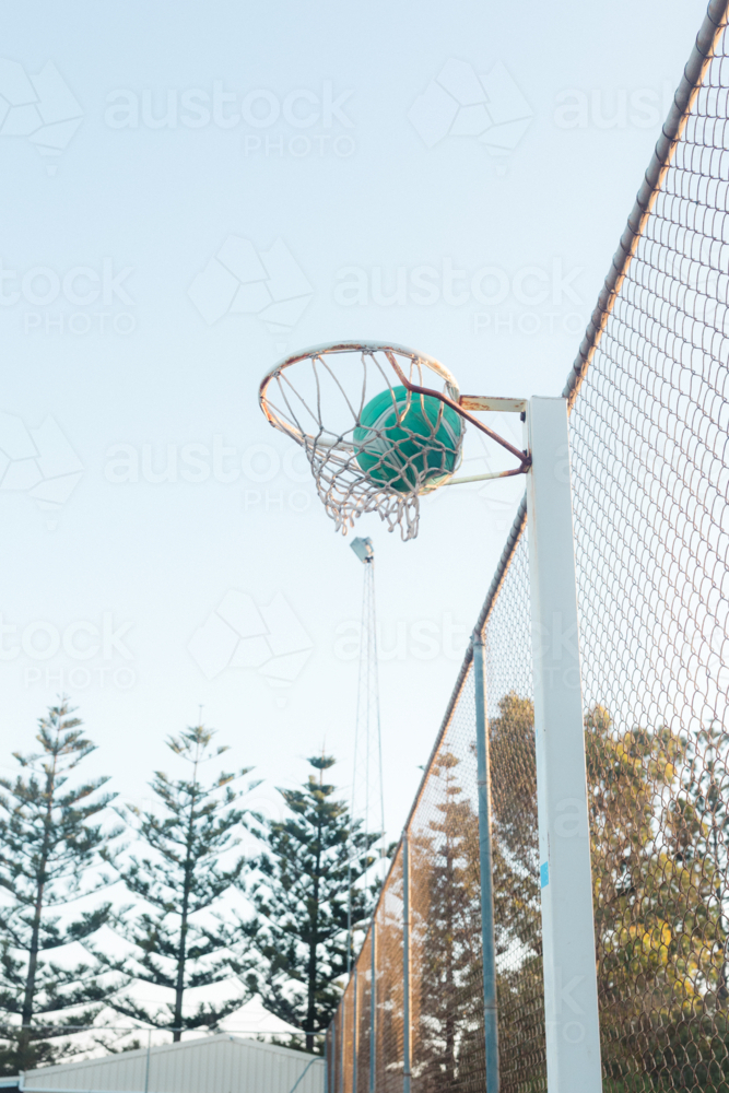 Ball going through the hoop at regional Australia netball court - Australian Stock Image