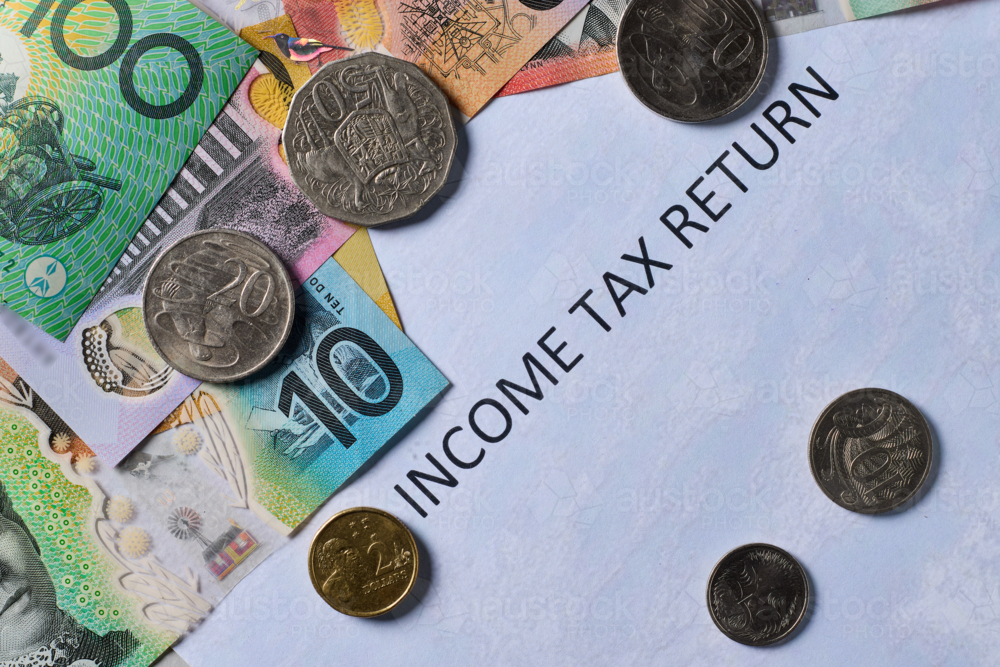Bank notes & coins  on top of tax return - Australian Stock Image