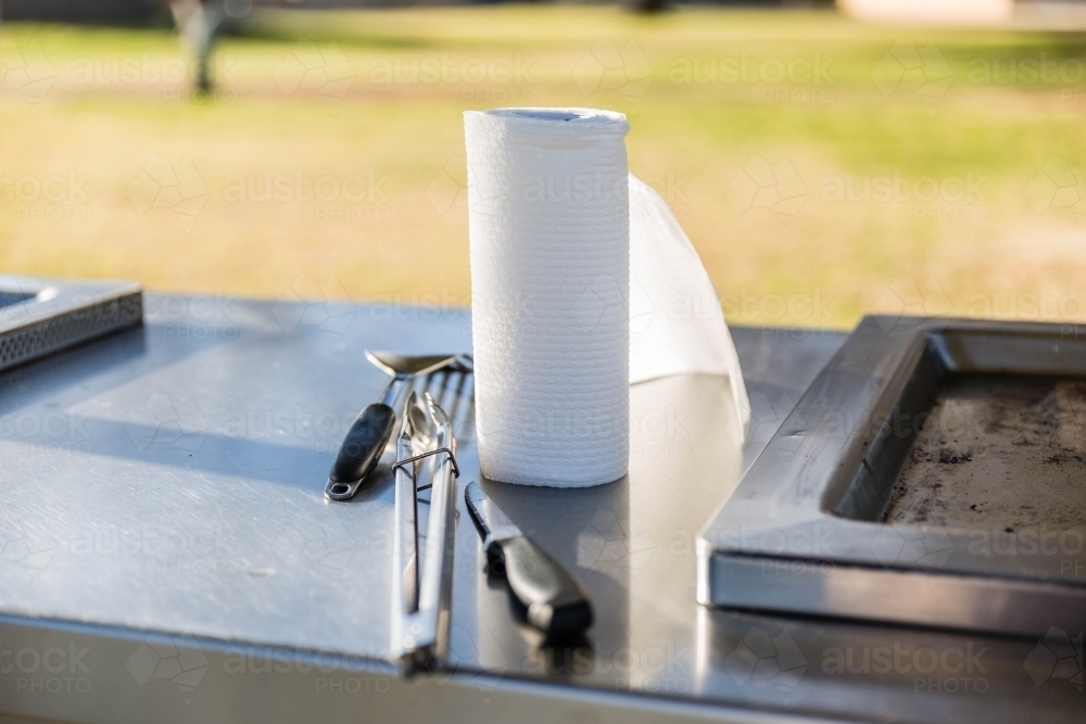 Barbecue utensils on stainless steel barbecue - Australian Stock Image