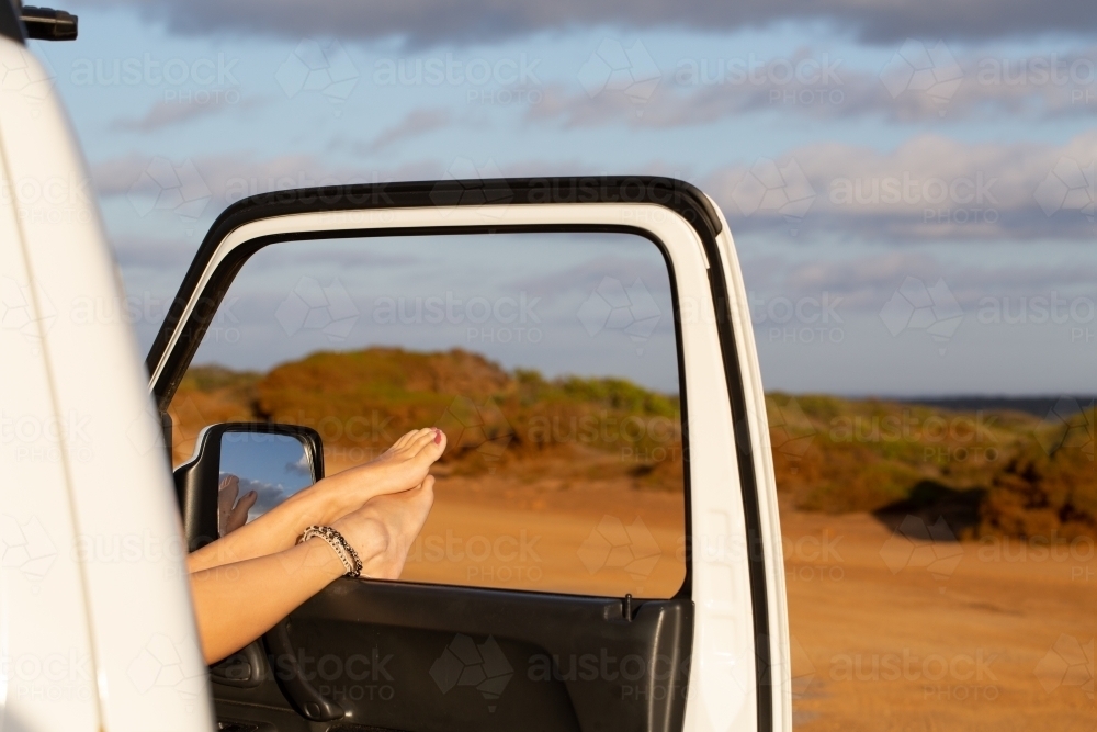 Bare feet resting out of car window - Australian Stock Image
