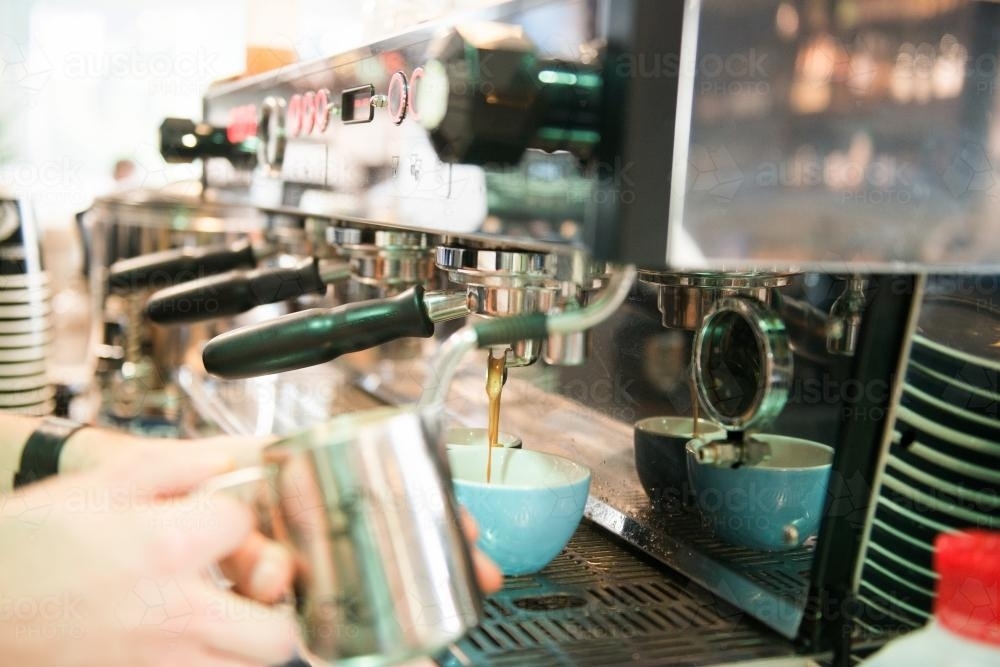 Barista making coffee at a commercial coffee machine - Australian Stock Image