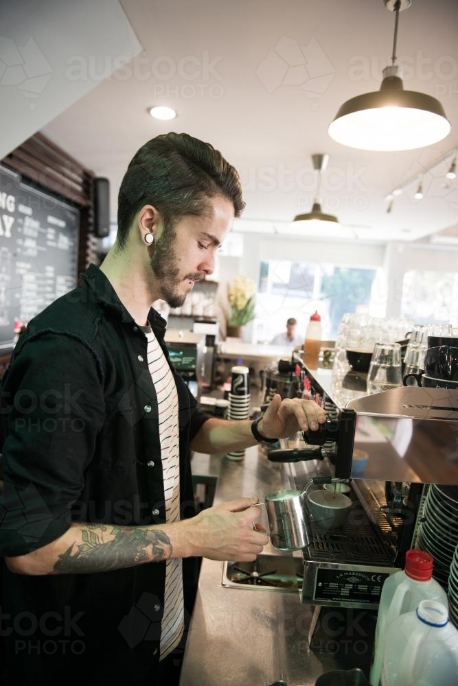Barista making coffee inside a cafe - Australian Stock Image