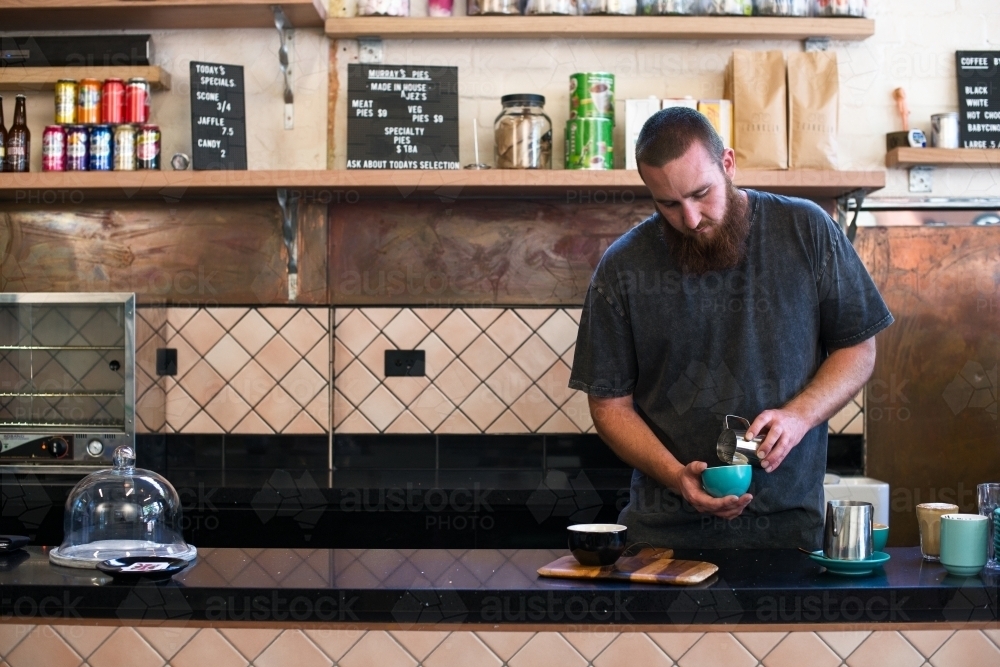 Barista making coffee inside cafe shop - Australian Stock Image