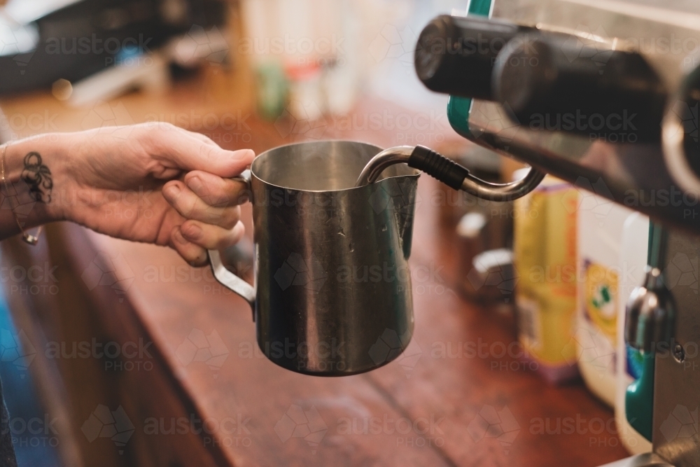Image of barista making coffee, steaming the milk Austockphoto