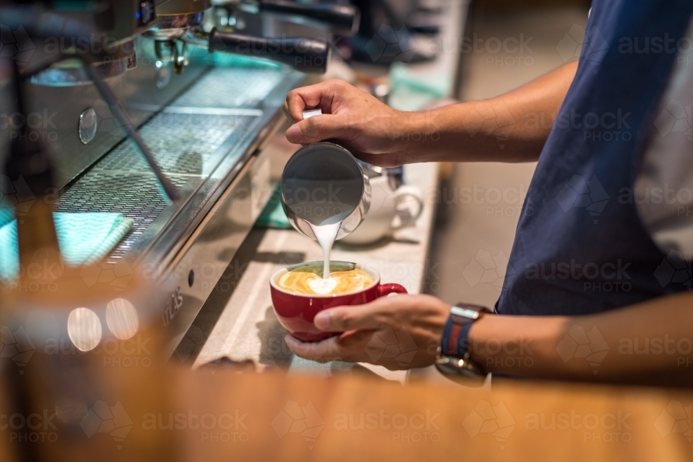 Barista pouring coffee at coffee machine - Australian Stock Image