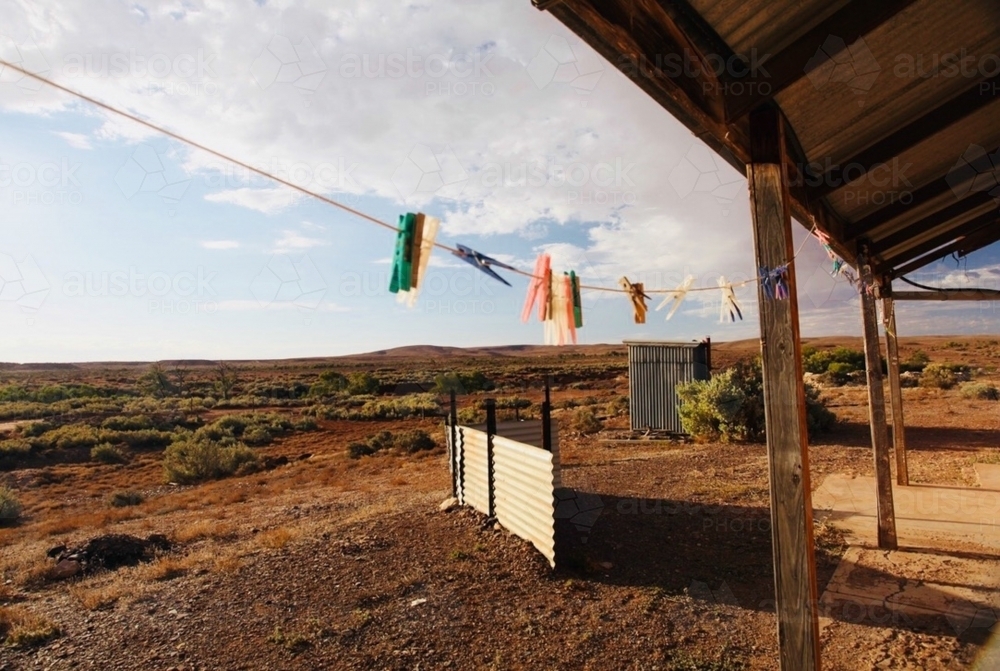 Barren landscape, pegs on line looking out from wooden dwelling - Australian Stock Image