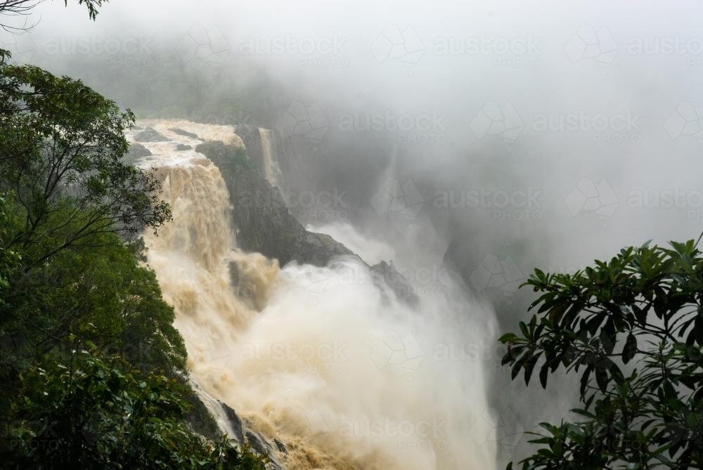 Barron Falls covered in cloud and mist from the power of the water after heavy rain - Australian Stock Image
