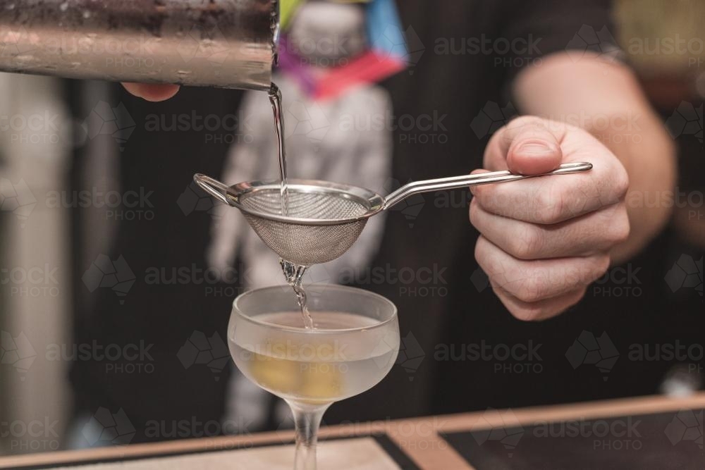 bartender pouring a cocktail - Australian Stock Image